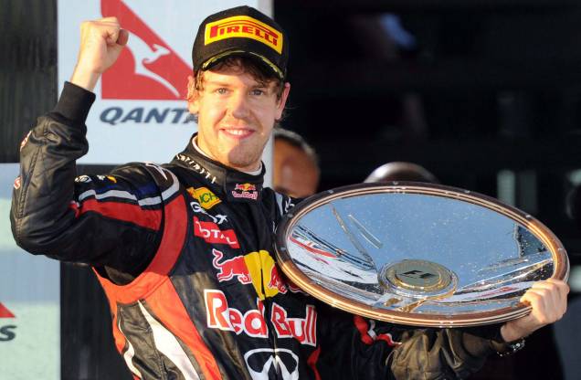 O piloto da Red Bull-Renault Sebastian Vettel da Alemanha gesticula no pódio após vencer o Grande Prêmio da Austrália de Fórmula 1 em Melbourne, em 27/03/2011. O piloto da Red Bull-Renault Sebastian Vettel da Alemanha gesticula no pódio após vencer o Grande Prêmio da Austrália de Fórmula 1 em Melbourne, em 27/03/2011.