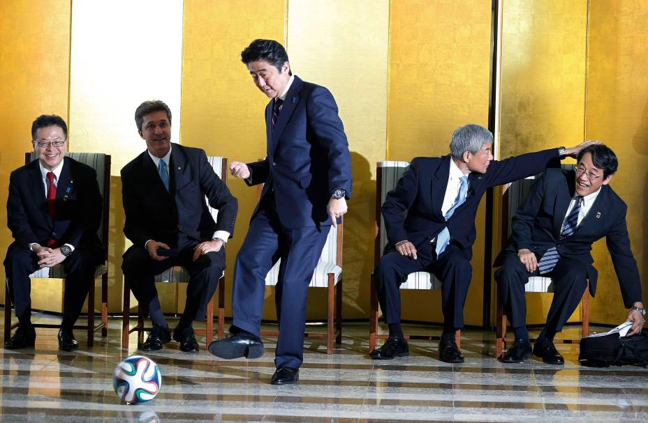 O ex primeiro-ministro do Japão, Shinzo Abe, chuta uma bola de futebol durante encontro com jogadores brasileiros em Brasília, 01/08/2014. O ex primeiro-ministro do Japão, Shinzo Abe, chuta uma bola de futebol durante encontro com jogadores brasileiros em Brasília, 01/08/2014.