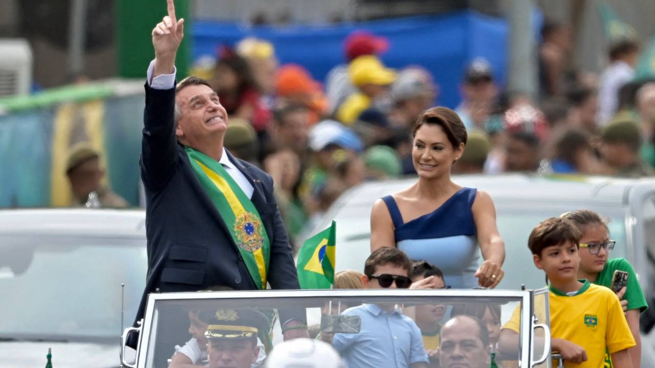 Brazilian President Jair Bolsonaro gestures next to First Lady Michelle Bolsonaro during a military parade to mark Brazil's 200th anniversary of independence in Brasilia, on September 7, 2022. (Photo by EVARISTO SA / AFP)