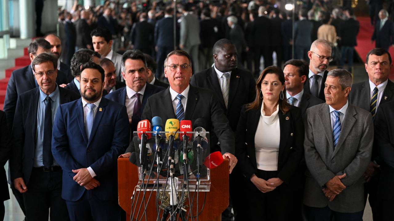 Brazilian President Jair Bolsonaro (C) makes a statement for the first time since Sunday's presidential run-off election, at Alvorada Palace in Brasilia, on November 1, 2022. - Brazil's Bolsonaro sais will 'comply' with constitution after poll loss. (Photo by EVARISTO SA / AFP)