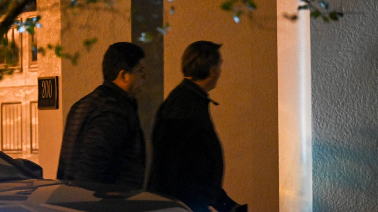 Former Brazilian President Jair Bolsonaro (R) arrives at his rental house after being discharged from the hospital at the Encore Resort at Reunion in Kissimmee, Florida, on January 10, 2023. - Defeated Brazilian president Jair Bolsonaro's stay in Florida as his supporters rioted at home presents awkward optics for the United States, which under President Joe Biden has vowed to champion democracy. (Photo by CHANDAN KHANNA / AFP)