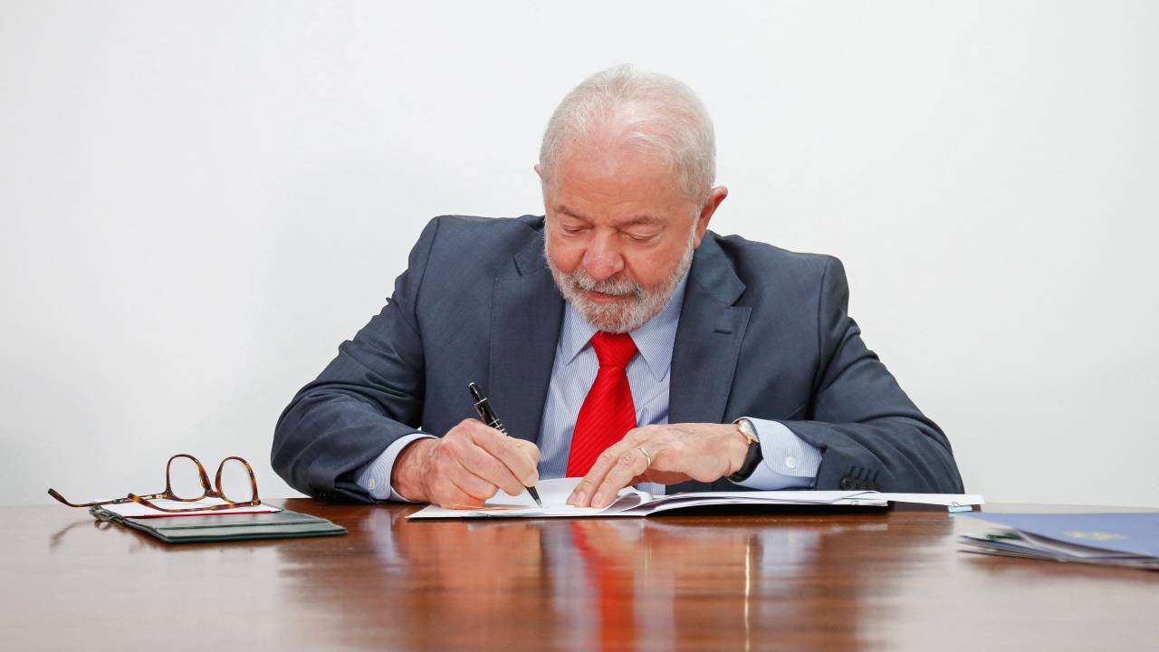 Brazil's President Luiz Inacio Lula da Silva signs a document of new economic measures at the Planalto Palace in Brasilia, on January 12, 2023. (Photo by Sergio Lima / AFP)