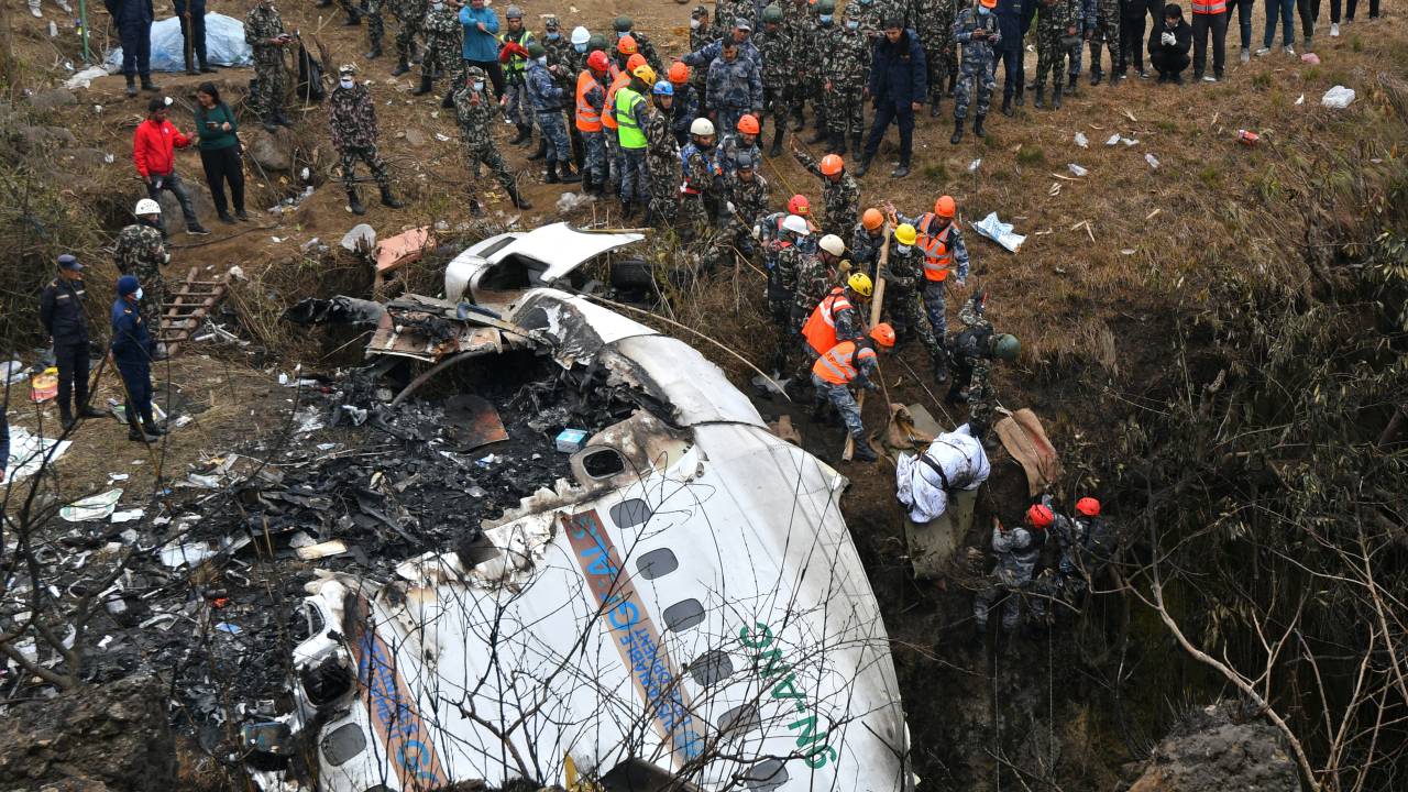EDITORS NOTE: Graphic content / Rescuers pull the body of a victim who died in a Yeti Airlines plane crash in Pokhara on January 16, 2023. - Nepal observed a day of mourning on January 16 for the victims of the nation's deadliest aviation disaster in three decades, with 67 people confirmed killed in the plane crash. (Photo by PRAKASH MATHEMA / AFP)