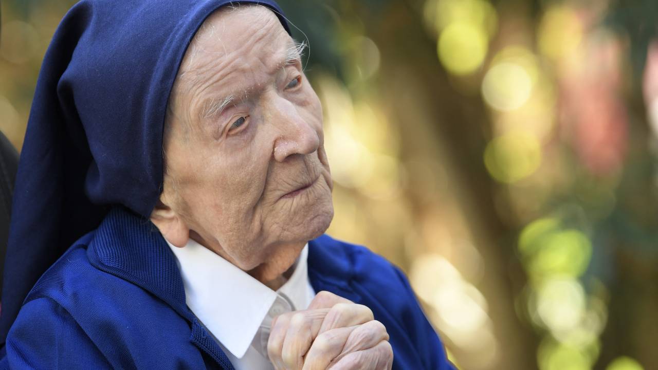 (FILES) In this file photo taken on February 10, 2021, Sister Andre, Lucile Randon in the registry of birth, the eldest French and European citizen, prays in a wheelchair, on the eve of her 117th birthday, in an EHPAD (Housing Establishment for Dependant Elderly People) in Toulon, southern France, where she has been living since 2009. - The world's oldest known person, Lucile Randon, known as Sister Andre, has died aged 118, her spokesman said on January 17, 2023. Randon was born in southern France on February 11, 1904, when World War I was still a decade away. (Photo by NICOLAS TUCAT / AFP)