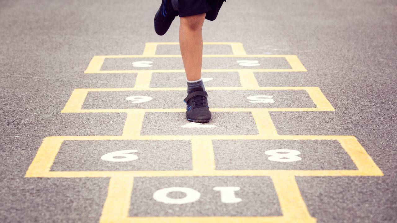 Child playing hopscotch on school playground