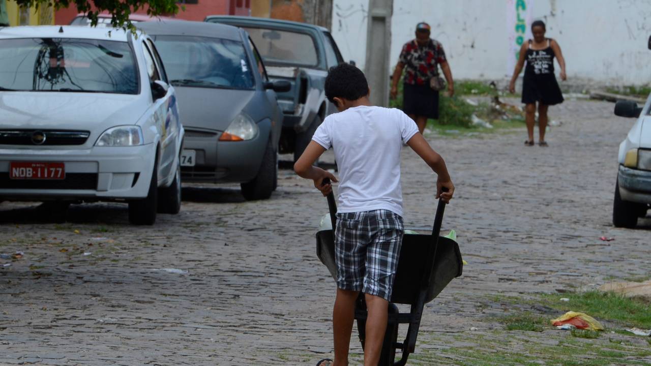 Aos 12 anos, menino falta à escola todas as segundas-feiras para trabalhar como carregador em uma feira de Natal