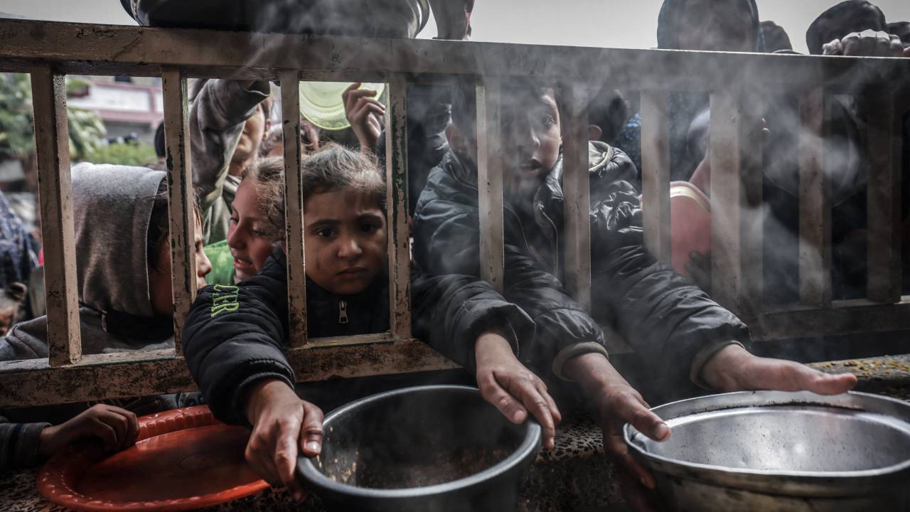 Crianças palestinas deslocadas se reúnem para receber comida em uma escola pública em Rafah, no sul da Faixa de Gaza. 19/02/2024