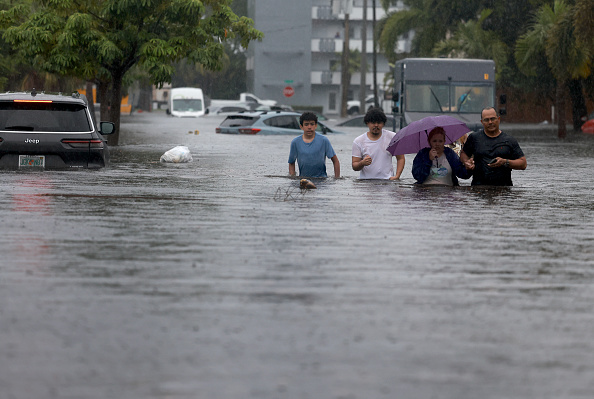 Pessoas se deslocando em meio à inundações após chuvas torrenciais atingirem Hollywood, na Flórida. 12/06/2024