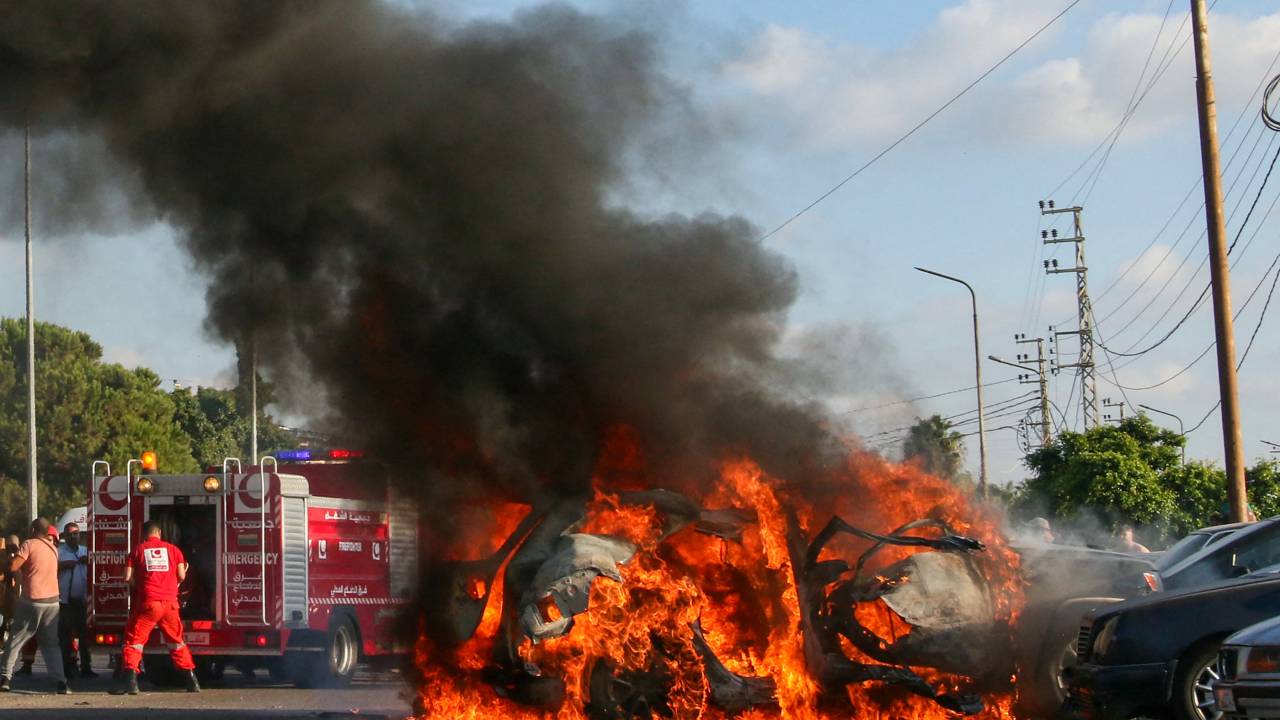 Firefighter arrive as a car burns following an Israeli strike in the southern Lebanese city of Sidon on August 9, 2024. A Lebanese security source said the Israeli strike on a vehicle in the southern city of Sidon killed a Hamas security official from the nearby Ain al-Helweh Palestinian refugee camp. (Photo by Mahmoud ZAYYAT / AFP)