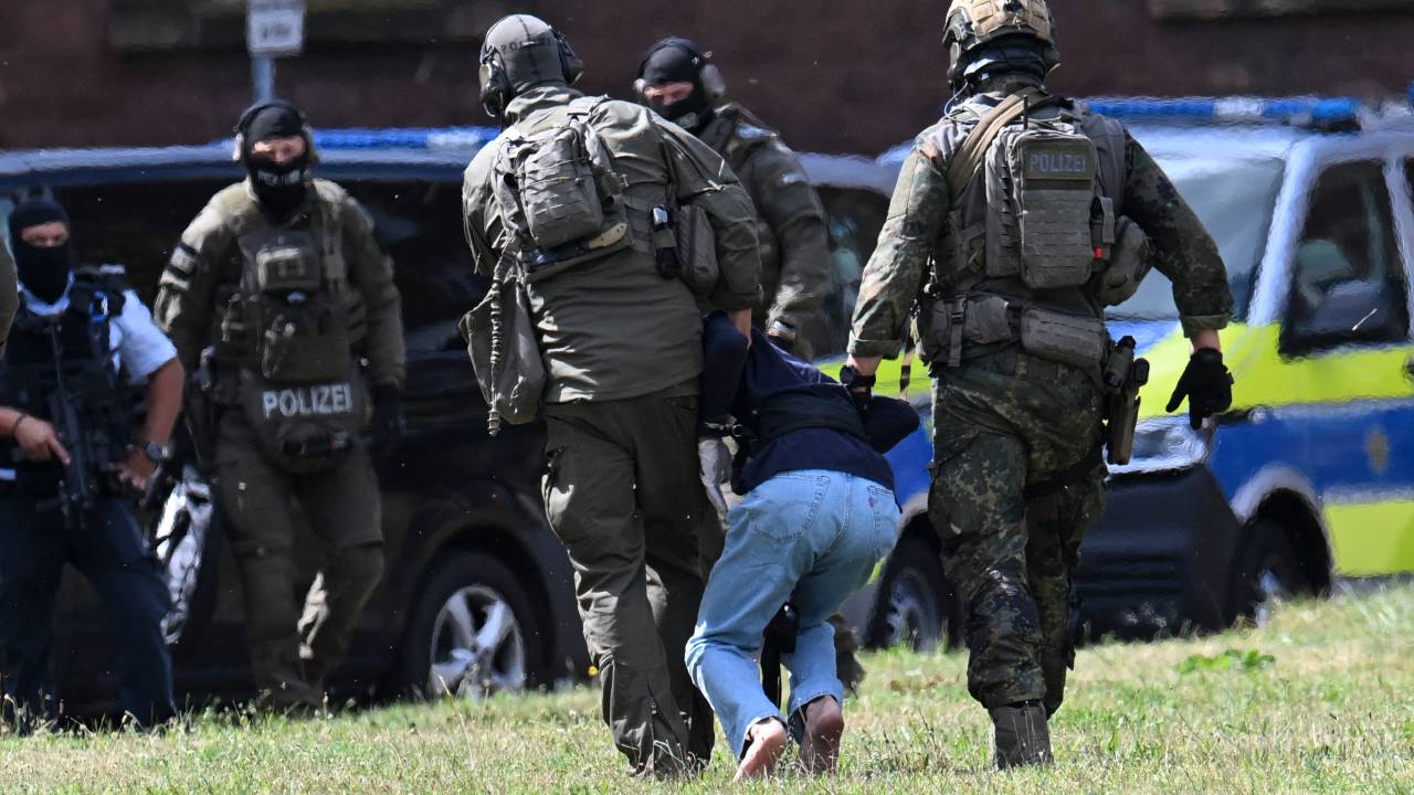 Members of a special police unit escort a man suspected to be responsible for the Solingen knife attack from a helicopter to the office of the Federal Prosecutor in Karlsruhe, southern Germany, on August 25, 2024. Police arrested the suspect in a raid at a hostel for asylum seekers on August 24, 2024, not far from the scene of the random attack during festivities to celebrate the 650th anniversary of Solingen, western Germany. Authorities said that the Syrian man had given himself up and confessed to killing three people and wounding several others in a knife rampage at a street festival. (Photo by THOMAS KIENZLE / AFP)