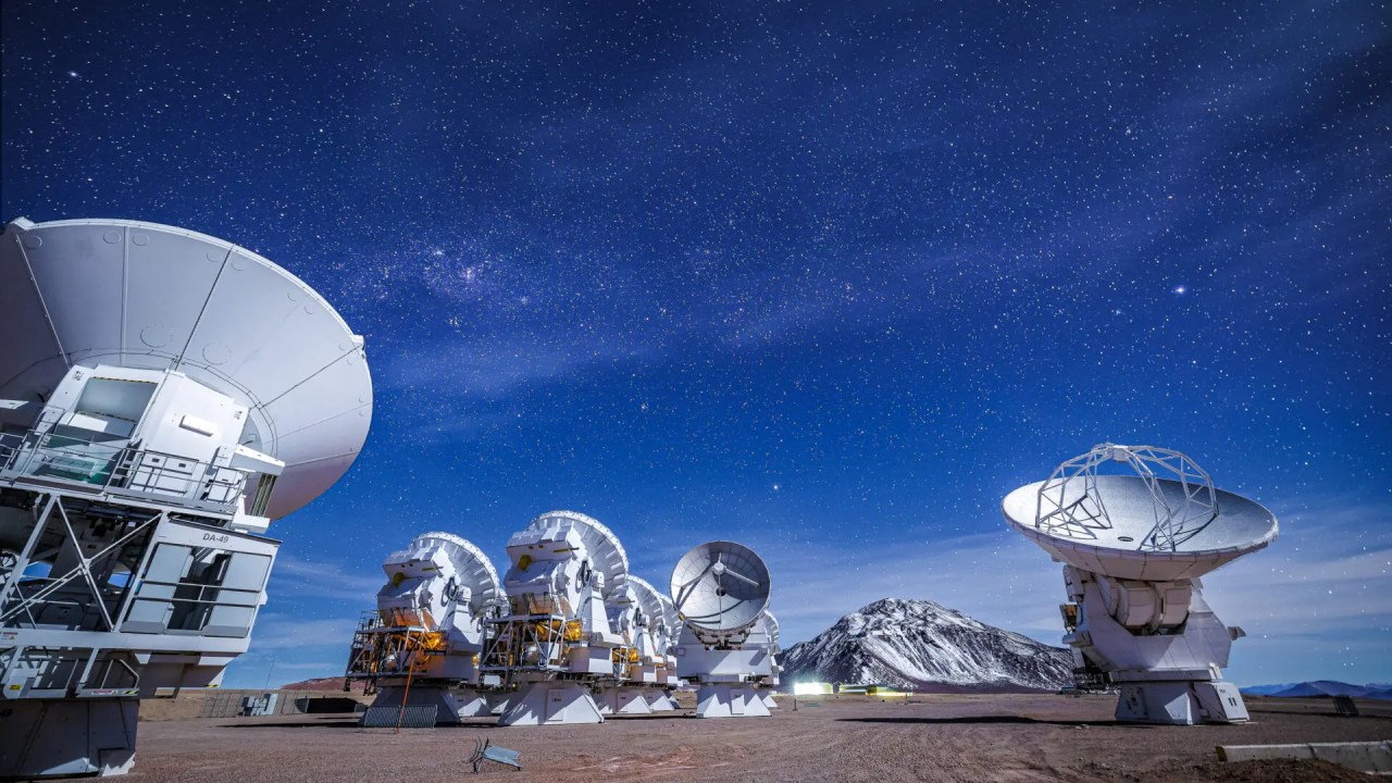 A beautiful view of the ALMA antennas working during the night, with the snowy Chajnantor mountain in the background. Credit: Alex Pérez