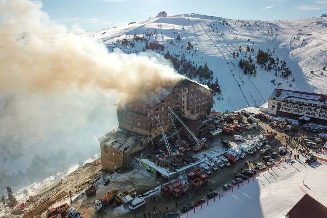 This handout photograph released by the Demiroren News Agency (DHA) on January 21, 2025, shows an aerial picture of a fire on the fourth floor of the 11-storey hotel in Bolu's Kartalkaya ski resort. A fire erupted early on January 21, 2025, at a hotel in a popular Turkish ski resort in the central province of Bolu, killing 10 people and injuring 32, the interior minister said. (Photo by DHA (Demiroren News Agency) / AFP) / - Turkey OUT / RESTRICTED TO EDITORIAL USE - MANDATORY CREDIT 
