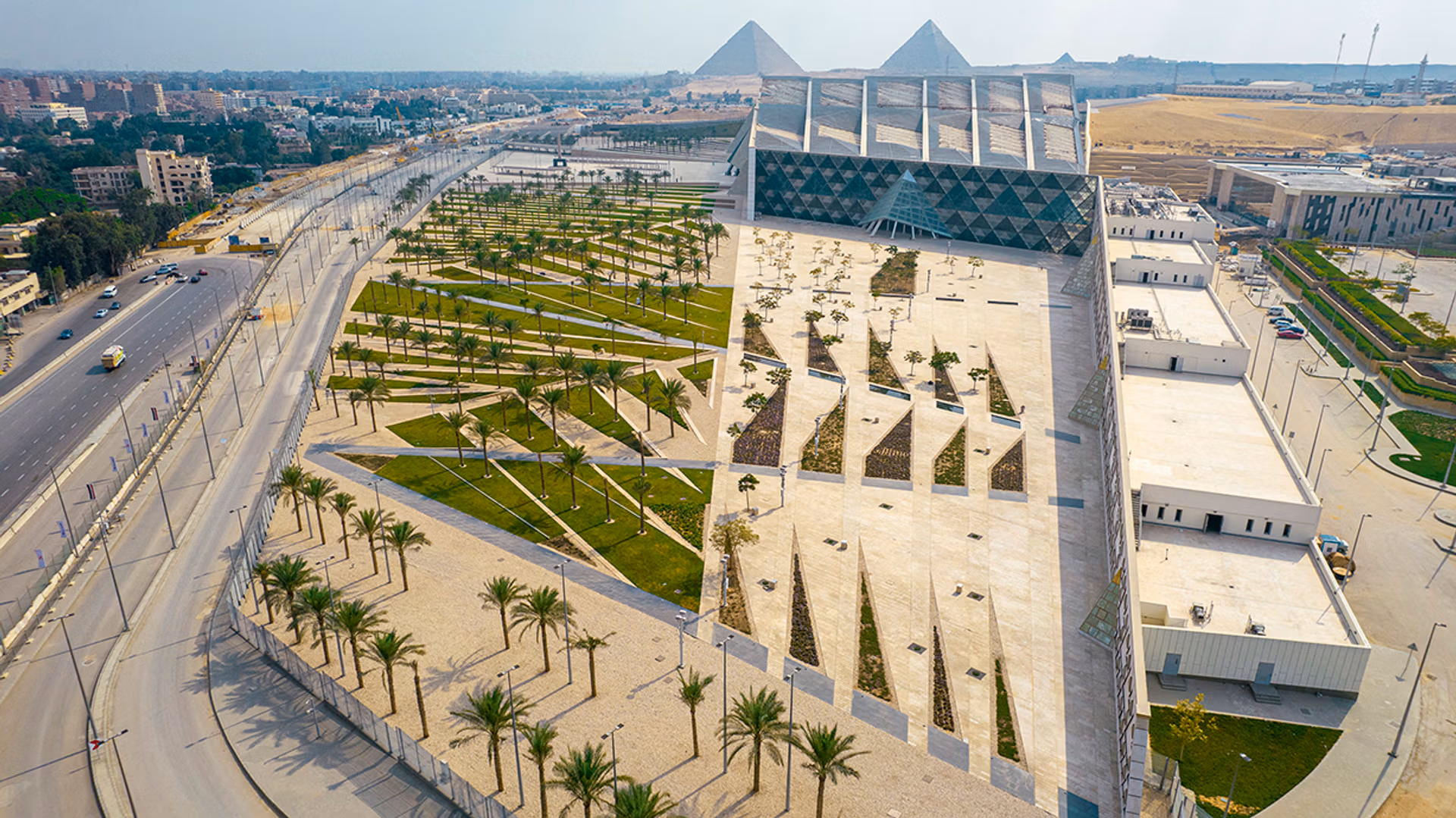 Integrado à paisagem histórica de Gizé, o novo museu egípcio oferece vista direta para as pirâmides e reúne mais de 100 mil artefatos antigos