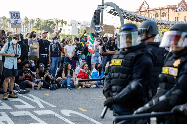 US-POLITICS-IMMIGRATION Protesters clash with law enforcement in the streets surrounding the federal building during a protest following federal immigration operations in Los Angeles, California, on June 8, 2025. Demonstrators torched cars and scuffled with security forces in Los Angeles on June 8, as police kept protestors away from the National Guard troops President Donald Trump sent to the streets of the second biggest US city. (Photo by RINGO CHIU / AFP)
