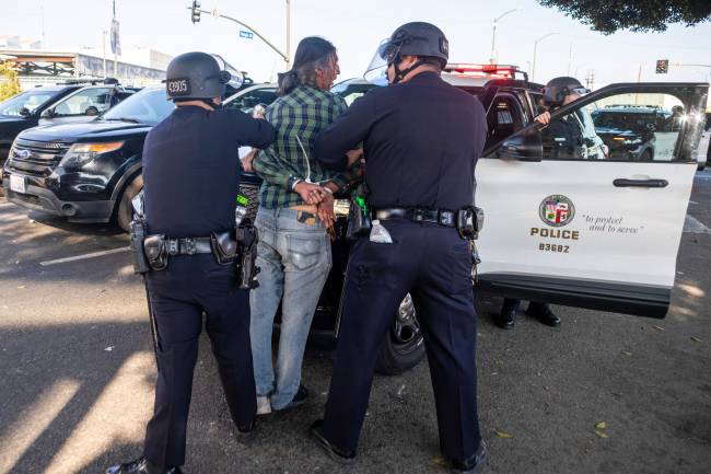 US-POLITICS-IMMIGRATION A man is arrested, as protesters clash with law enforcement in the streets surrounding the federal building during a protest following federal immigration operations in Los Angeles, California, on June 8, 2025. Demonstrators torched cars and scuffled with security forces in Los Angeles on June 8, as police kept protestors away from the National Guard troops President Donald Trump sent to the streets of the second biggest US city. (Photo by RINGO CHIU / AFP)