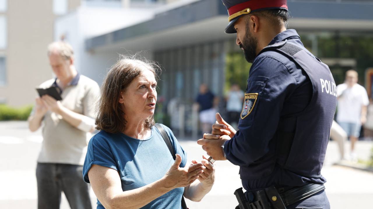 Elke Kahr (L), mayor of Graz, talks with a policeman close to a school where several people died in a shooting, on June 10, 2025 in Graz, southeastern Austria. Ten people died after a suspected shooter opened fire in a southeastern Austrian school, press agency APA quoted Graz city mayor Elke Kahr as saying. Several students and at least one adult are among those killed, Kahr confirmed to APA. (Photo by ERWIN SCHERIAU / APA / AFP) / Austria OUT
