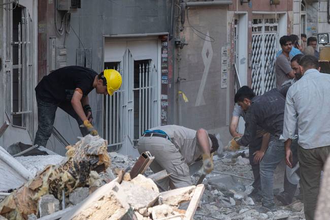 Israeli Attacks On Iran Iranian people work at the scene of a destroyed residential building due to Israeli attacks in Tehran, Iran, on June 13, 2025. (Photo by Morteza Nikoubazl/NurPhoto via Getty Images)