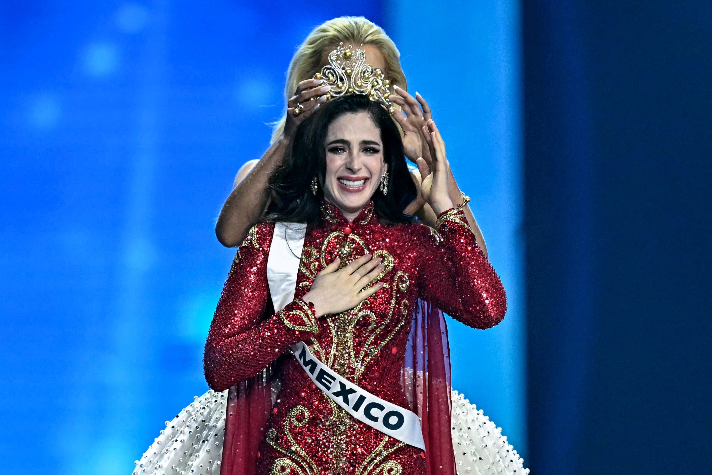 Miss Mexico Fatima Bosch (C) is crowned as she celebrates winning the 2025 Miss Universe pageant in Nonthaburi, north of Bangkok, on November 21, 2025. (Photo by Lillian SUWANRUMPHA / AFP)