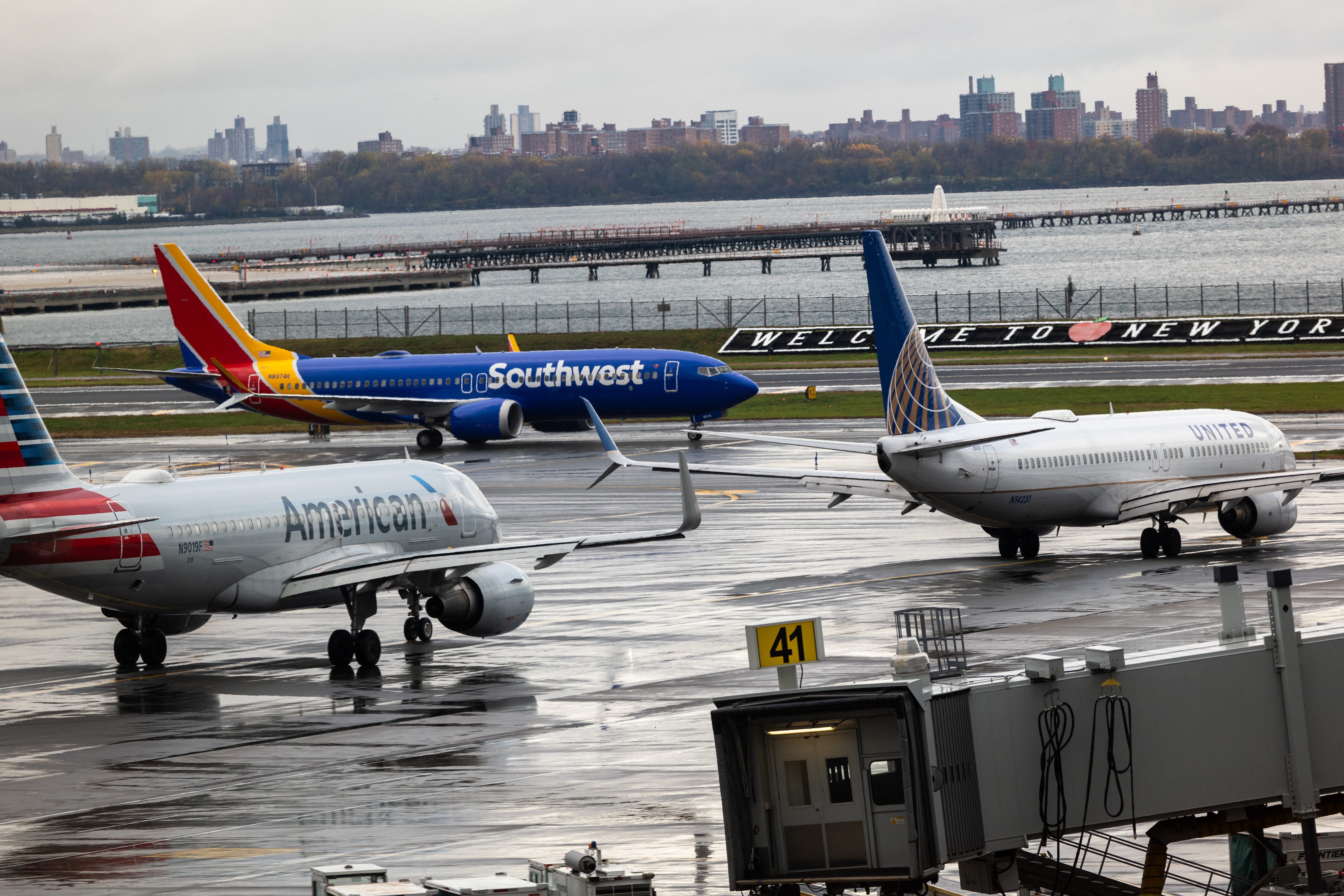 NOVA YORK - 10 DE NOVEMBRO: Aviões alinhados na pista do Aeroporto LaGuardia em 10 de novembro de 2025, na cidade de Nova York. Aeroportos em todo o estado de Nova York têm sofrido atrasos e cancelamentos de voos, já que as companhias aéreas estão reduzindo o número de voos em dezenas dos principais aeroportos dos EUA para aliviar a pressão sobre os controladores de tráfego aéreo, que estão trabalhando sem receber salário durante a paralisação do governo