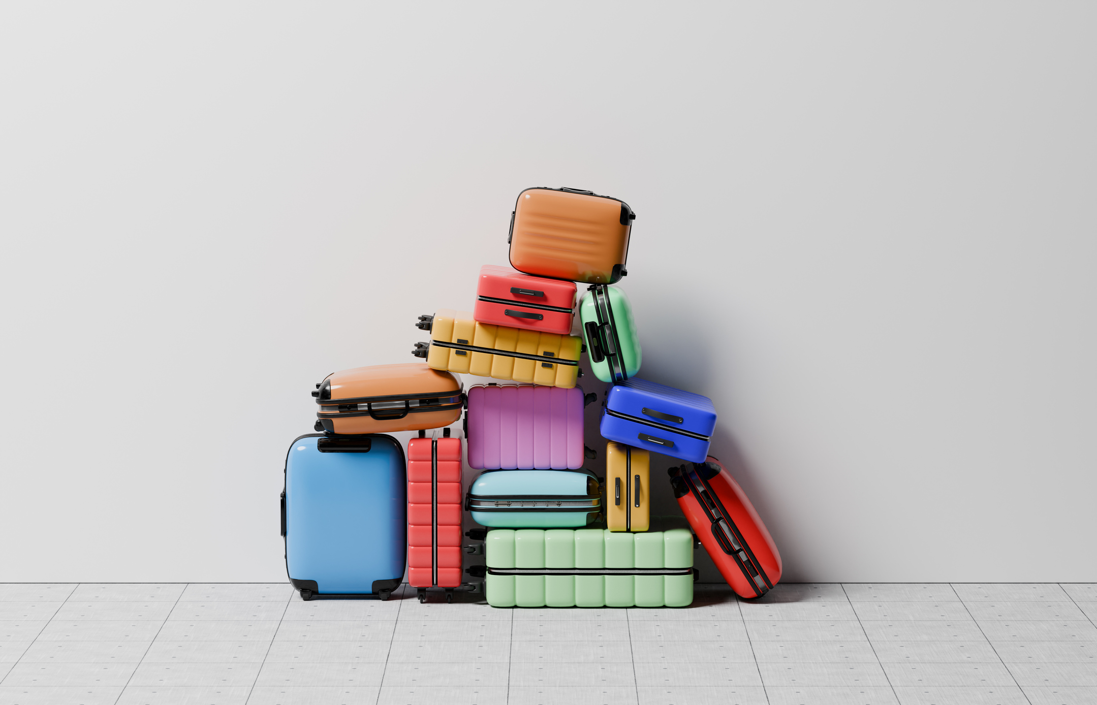 Large stack of colourful suitcases against wall
