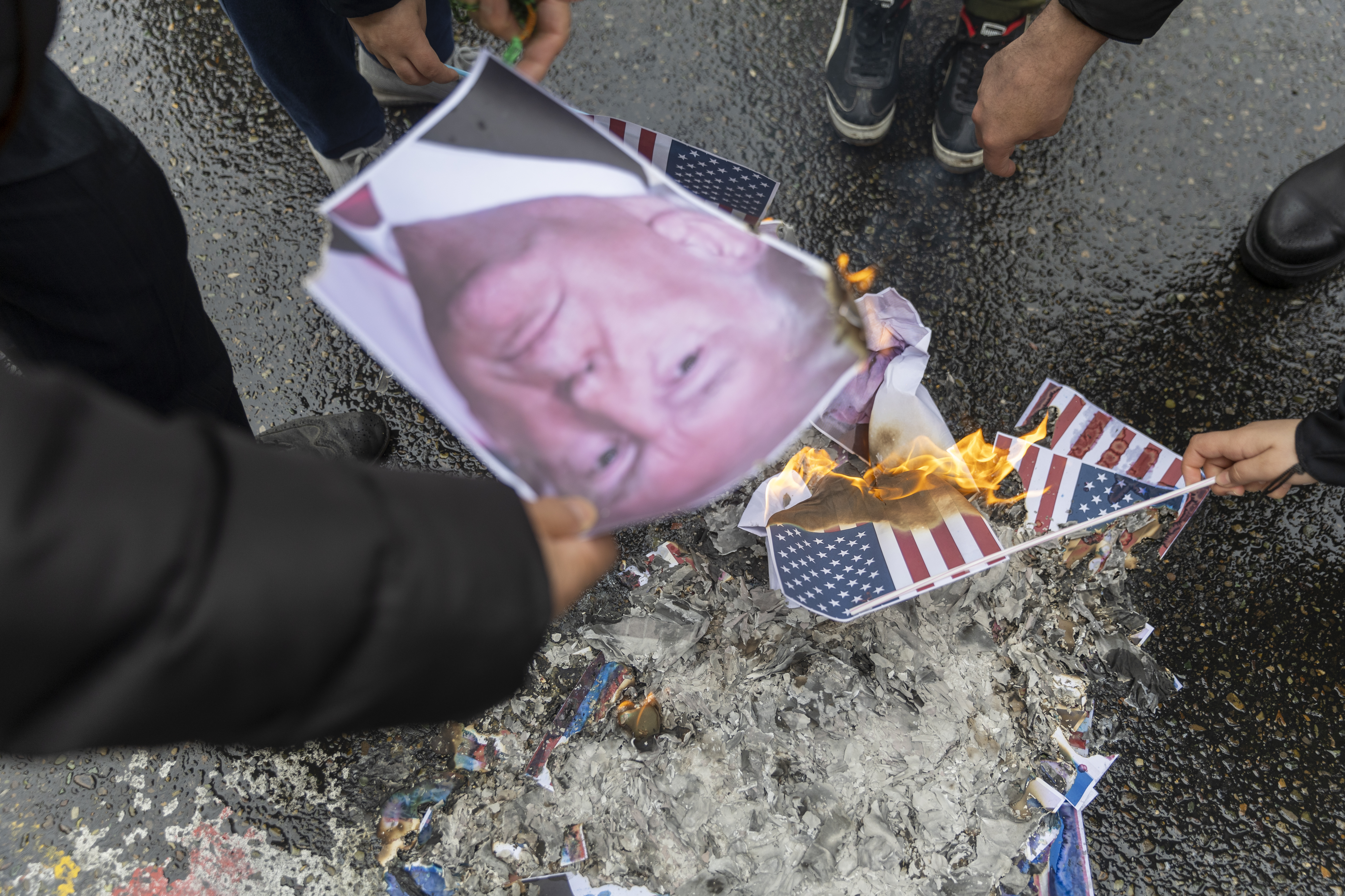 Pessoas queimam bandeiras dos EUA e retratos de Donald Trump em Teerã, capital do Irã